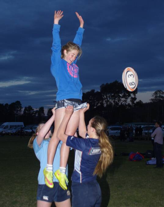 UPLIFTING: Amy Nicholls and Isobel Burgun help Elke O'Rourke in a supported jump as they practise line-outs at the Empower Rugby program. Photo: Darryl Fernance