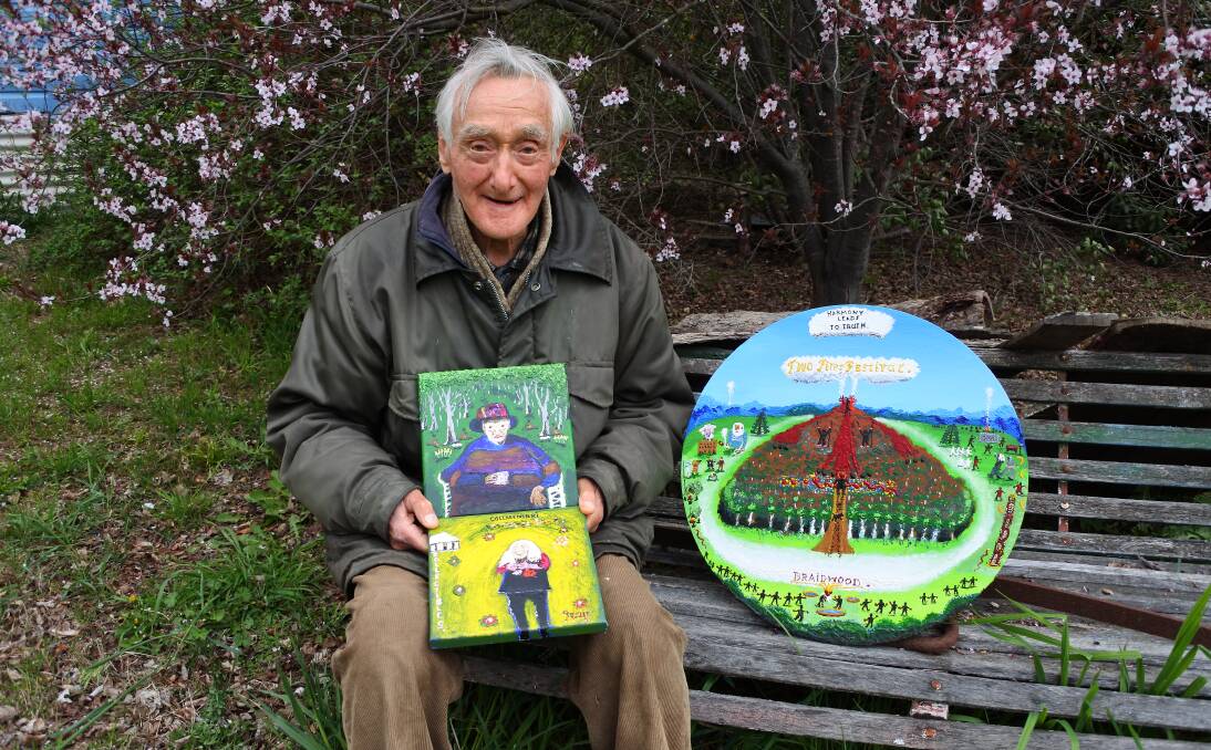 Jack Featherstone: The artist holds two smaller canvases (portraits of Merrie Hamilton and Judith Wright) with the larger circular painting, donated as the major prize for the Two Fire Festival next May. Photo: Bronwyn Haynes