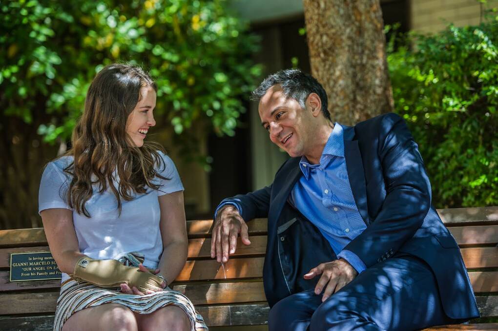 There is an obvious rapport between Canberra plastic surgeon Dr Ross Farhadieh and his young patient Sarah Hazell who today can use her re-attached right hand to write, drive, swim, eat with. Photo: Karleen Minney.