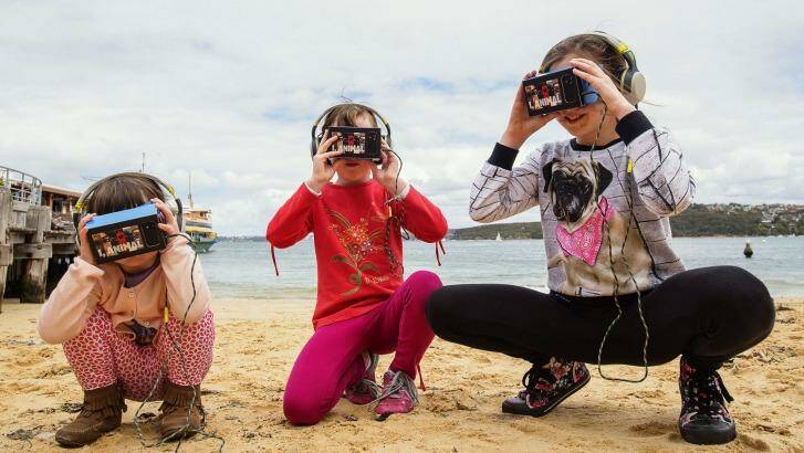 Sprays, Avalon and Anais Pitcher using iChicken virtual reality gear at Manly Wharf. Photo: Christopher Pearce