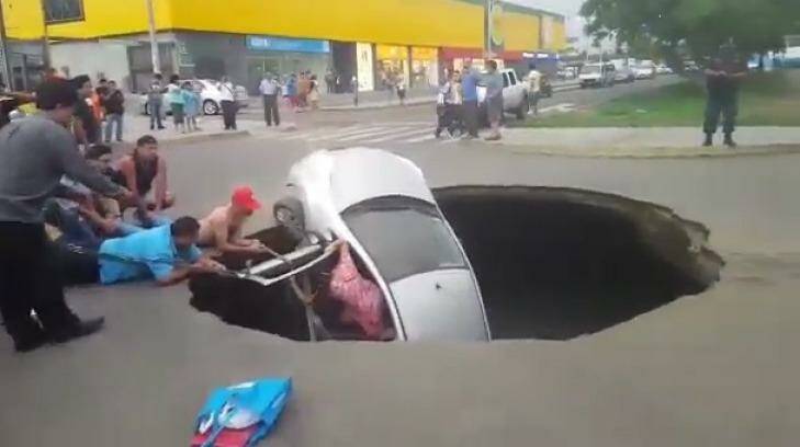 The dramatic rescue as a car disappears into a sinkhole in Peru.