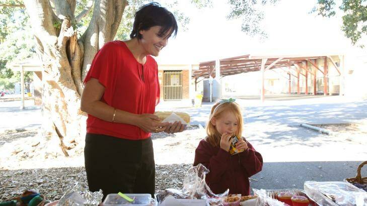 Strathfield Labor candidate Jodi McKay discussing the cake stall with a young supporter at Croydon Park public school. Photo: Louise Kennerley