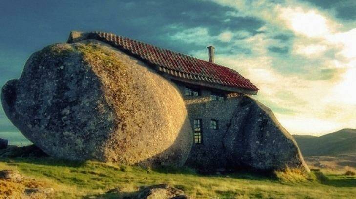 A rock house in Portugal wedged between boulders.