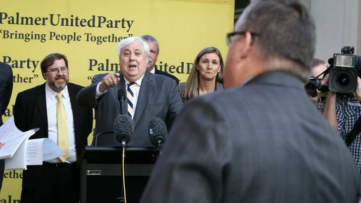 PUP leader Clive Palmer exchanges words with government whip Ewen Jones during a press conference at Parliament House on Thursday. Photo: Alex Ellinghausen