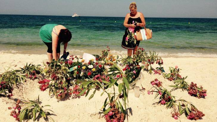 DonnaMarie Douglas from Glasgow (right) and a friend lay flowers at the makeshift memorial on the beach in front of the Hotel Imperial Marhaba. Photo: Ruth Pollard