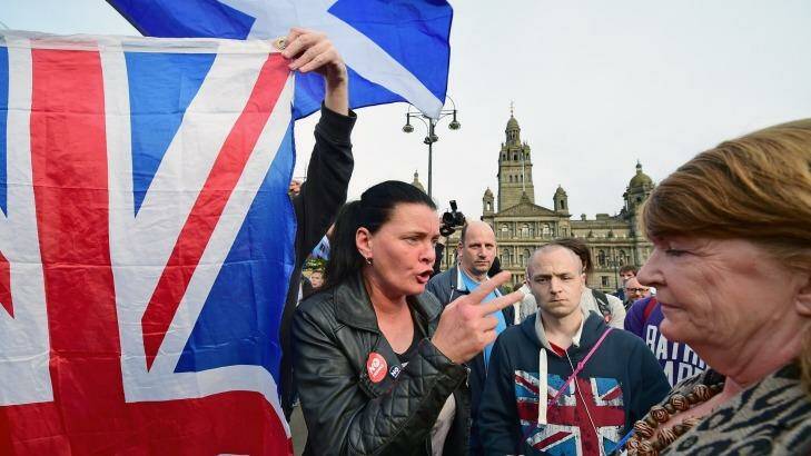 Heated debate ... A yes supporter talks with a man and a woman with a Union flag in George Square in Glasgow, Scotland. Photo: Jeff J Mitchell/Getty Images