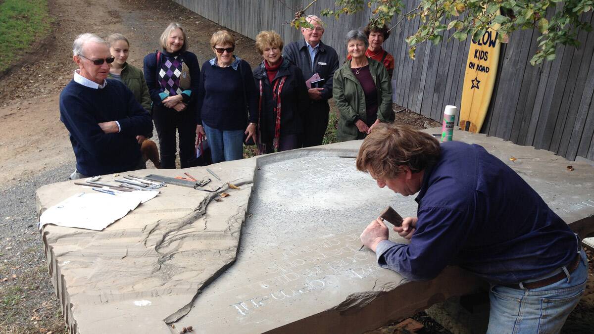 Ian Marr at work with Braidwood Social Justice Group looking on.  