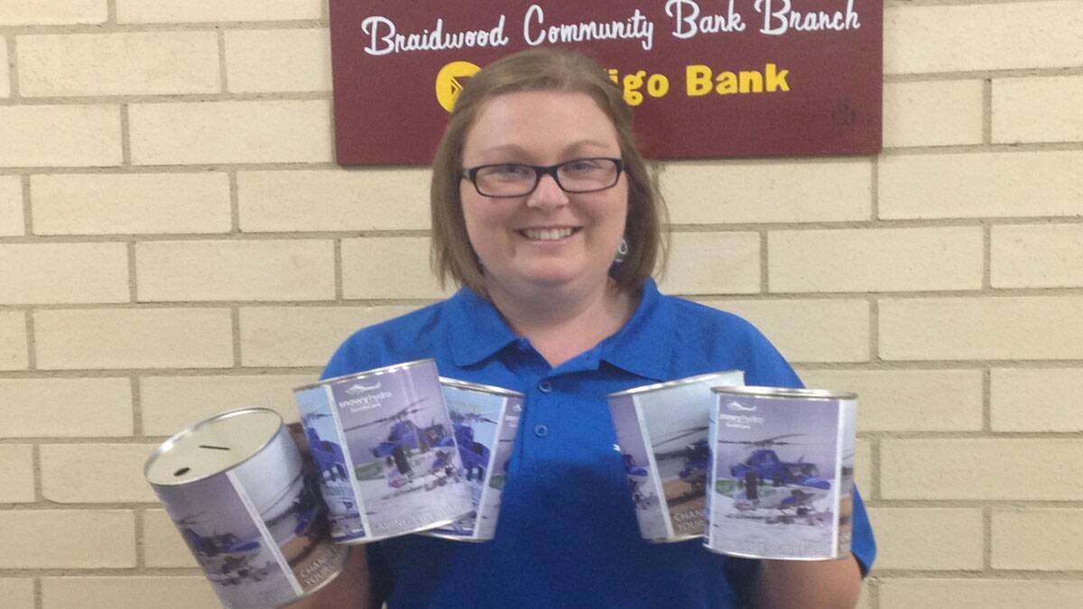 Braidwood Community Bank staff member Elise Albert with some of the Snowy Hydro SouthCare collection tins. 
