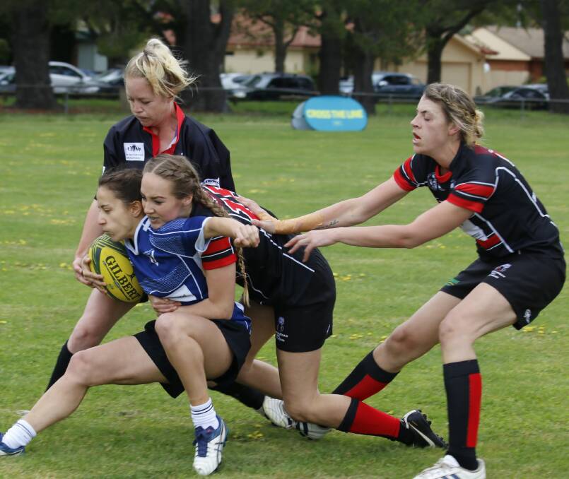 WIDOWS TACKLE ROYALS: Jay Coble, Charlotte Horan and Liv Laurie tackle a member of the Canberra Royals. Picture: Kathy Toirkens.