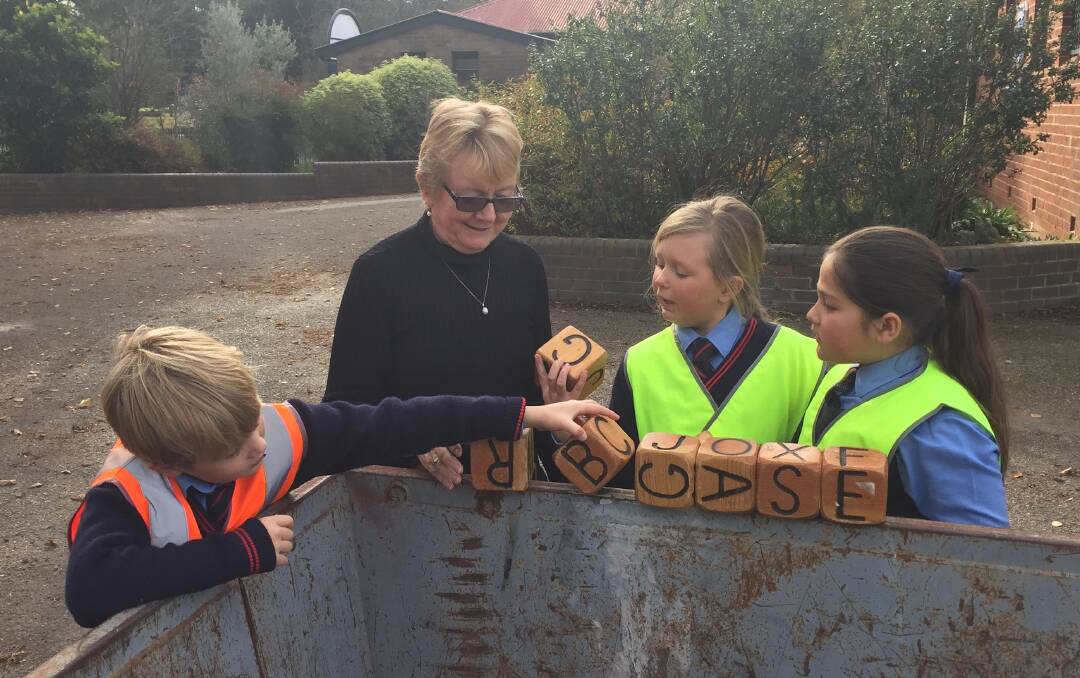 BUILD THEM UP: Ben, Amelia and Bally help principal Trish Ferlitsch reorganise items in storage in the lead-up to building works at St Bede's. Photo: Elspeth Kernebone