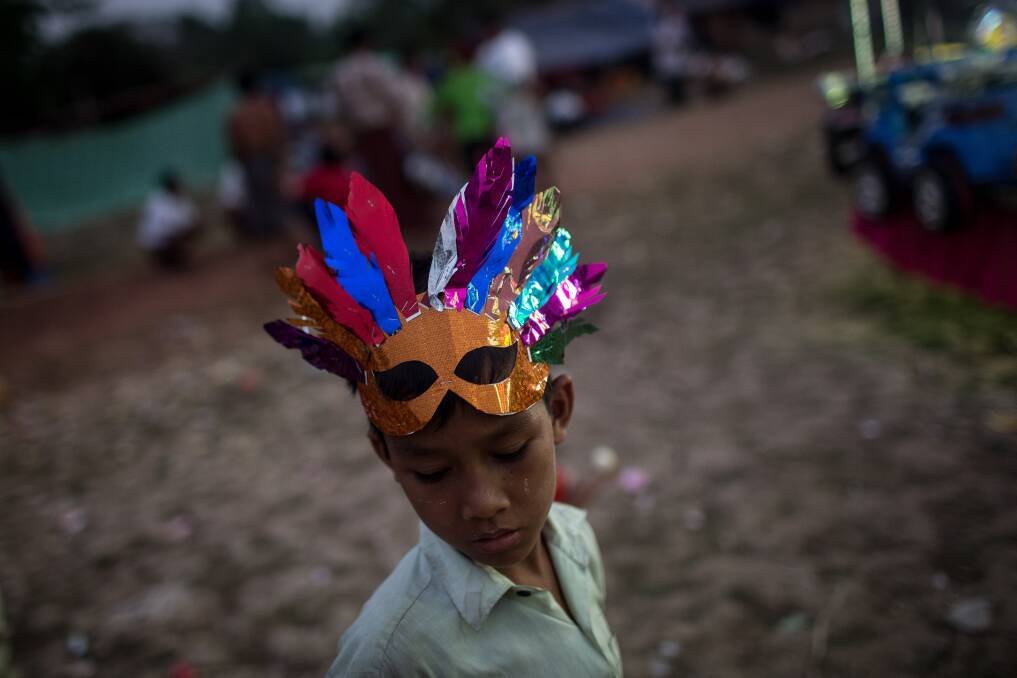 A boy is seen wearing a mask at a rural carnival in South Dagon Township on February 14, 2013 in Yangon, Burma. Photo by Chris McGrath/Getty Images