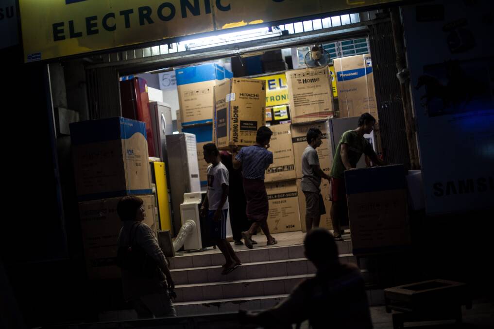 Workers move merchandise at an electronics store on February 10, 2013 in Yangon, Burma. Photo by Chris McGrath/Getty Images