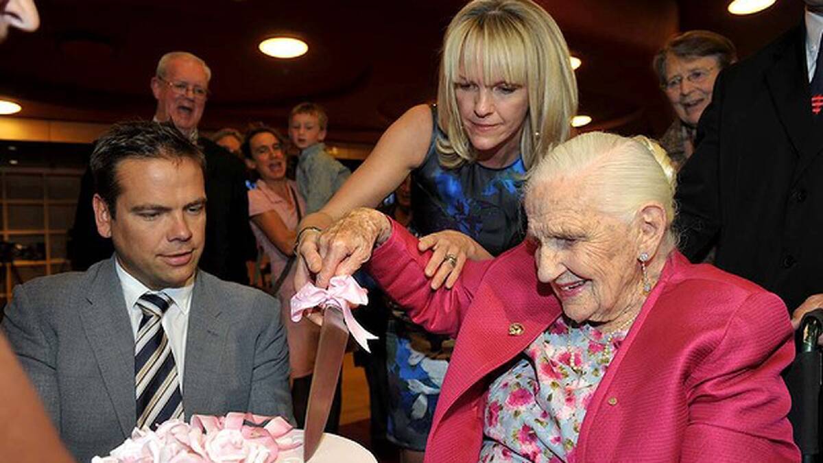 Dame Elisabeth gets ready to cut the cake at her 103rd birthday celebrations. Photo: Pat Scala