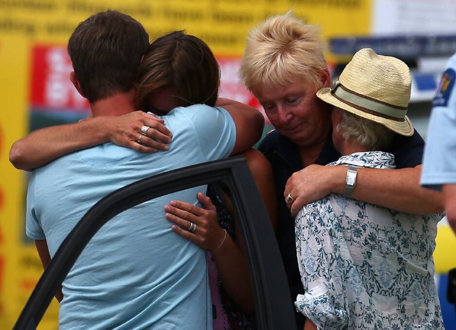 People grieve outside the Muriwai Surf Lifesaving Club after a swimmer died in a fatal shark attack at Muriwai Beach on February 27, 2013 in Auckland, New Zealand. Photo by Phil Walter/Getty Images