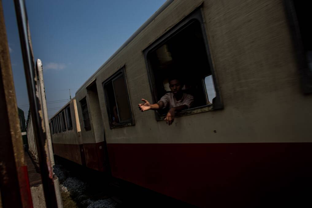 A man hangs his hands out of a moving train window on February 13, 2013 in Yangon, Burma. Photo: Chris McGrath/Getty Images
