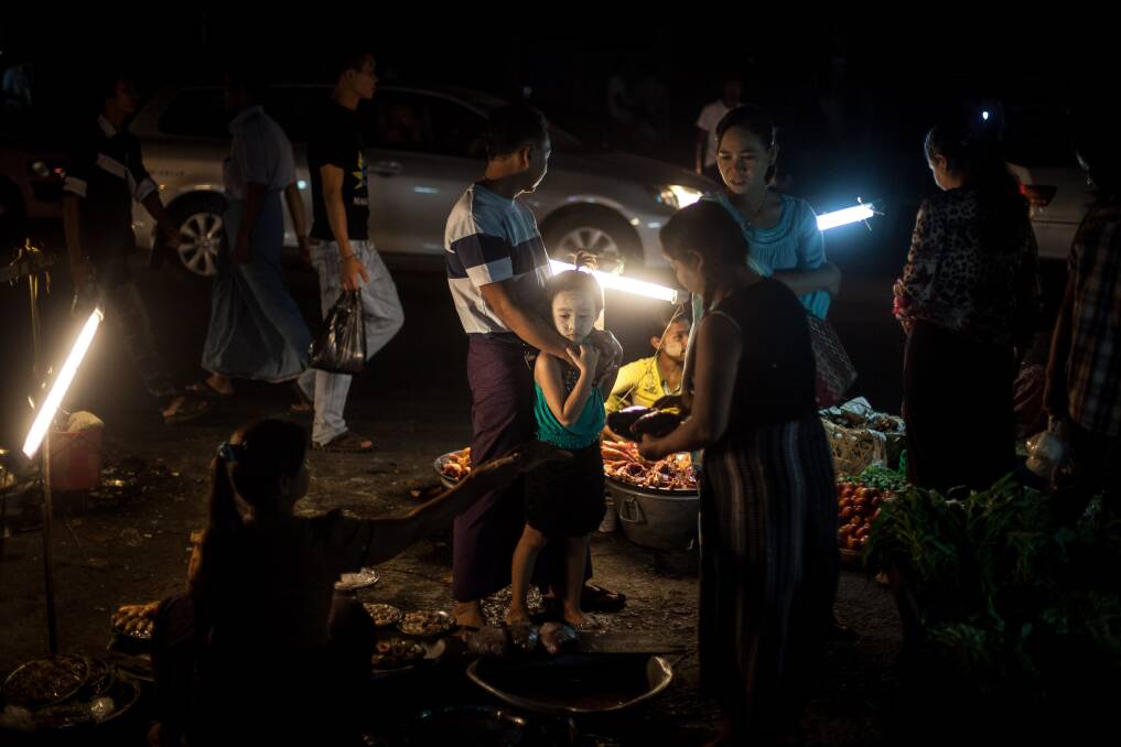 A family buys fish from a market stall February 10, 2013 in Yangon, Burma. Photo by Chris McGrath/Getty Images
