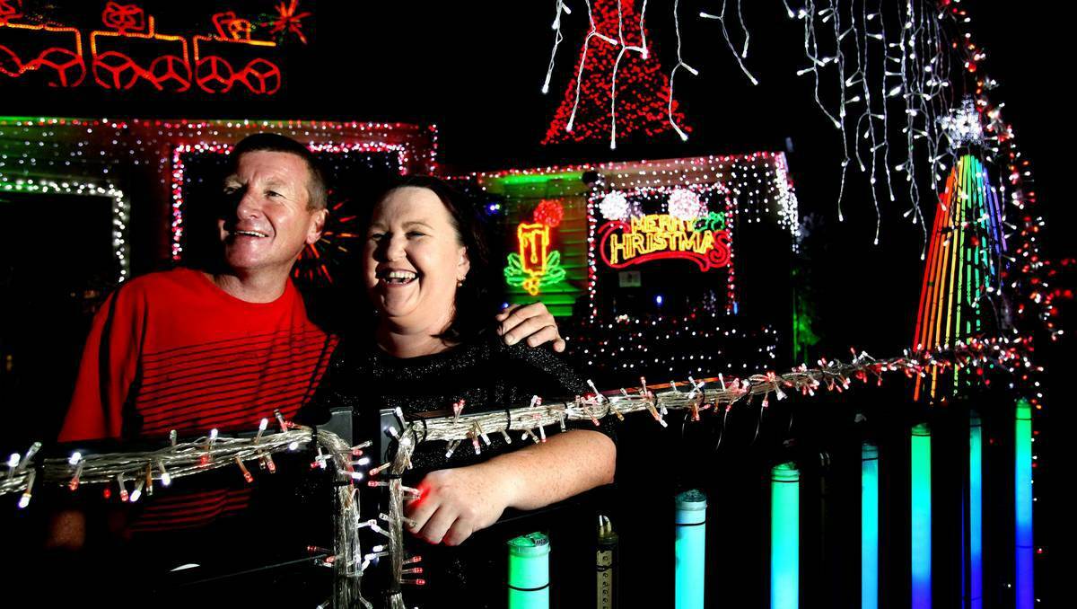 Glenn Sawyer and his wife, Leesa, in front of their lit-up house in Cardiff last night. Photo: Simone De Peak/The Herald