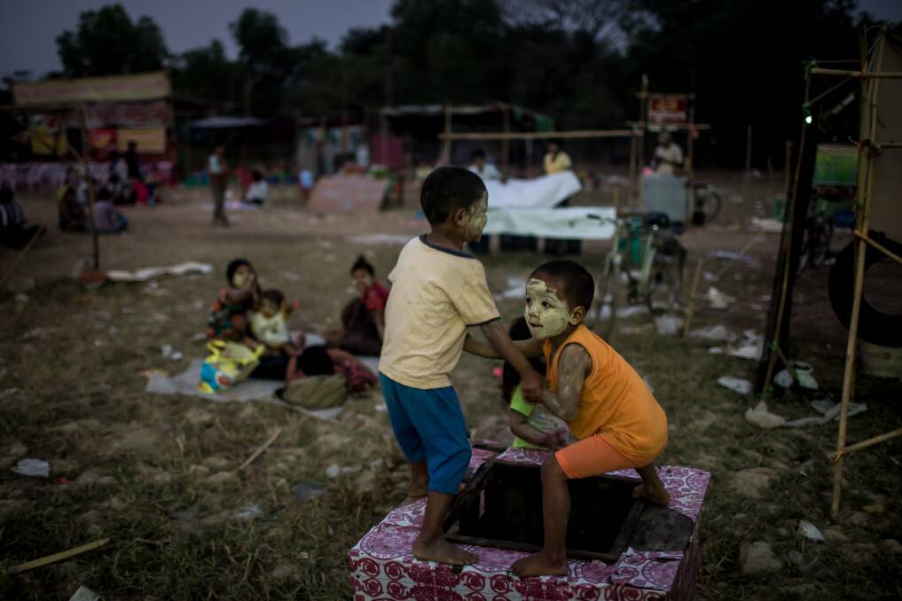 Two boys wrestle over a water hole amusement stand at a rural carnival in South Dagon Township on February 14, 2013 in Yangon, Burma. Photo: Chris McGrath/Getty Images