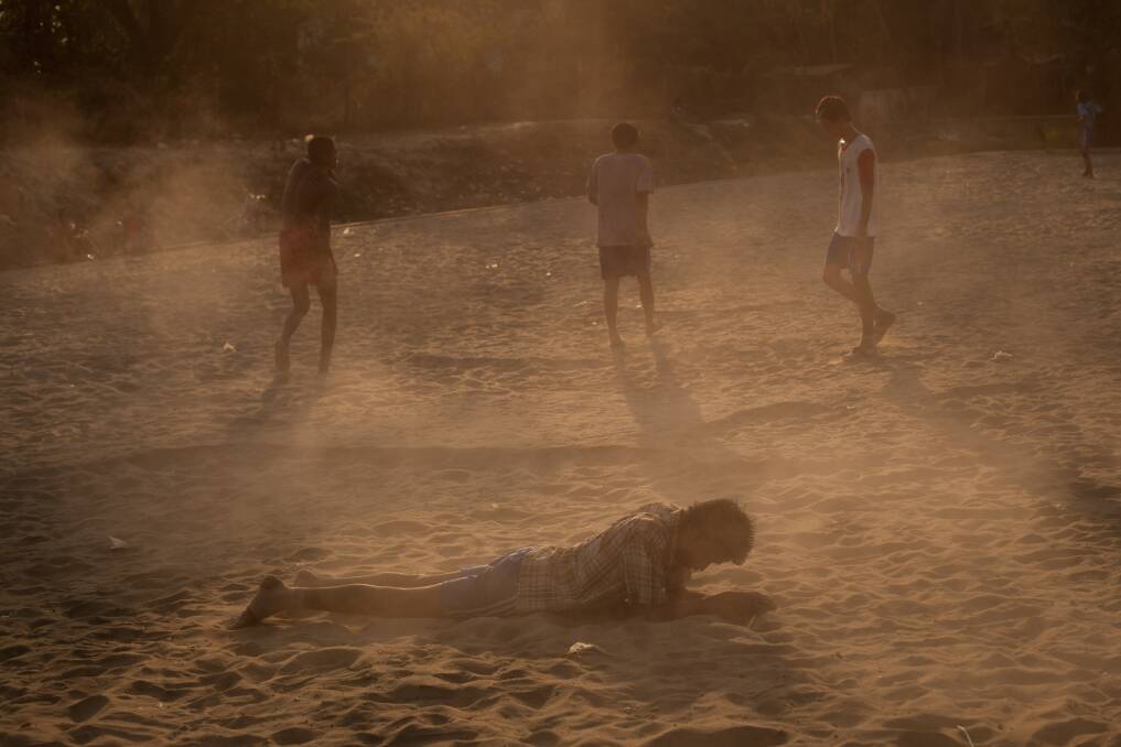 A man lays in the sand after a goal was scored during a soccer match in Dala Township on February 11, 2013 in Yangon, Burma. Photo: Chris McGrath/Getty Images