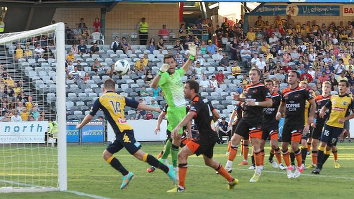 Number fourteen Central Coast Mariners player Michael McGlinchey heads the ball on the line to score. Photo: Brendan Esposito