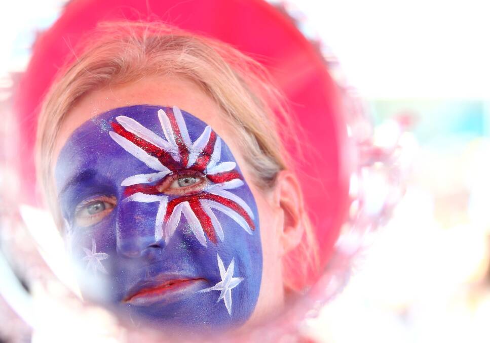 A woman looks at her freshly painted face in the mirror during day two of the 2013 Australian Open. Photo by Marianna Massey/Getty Images