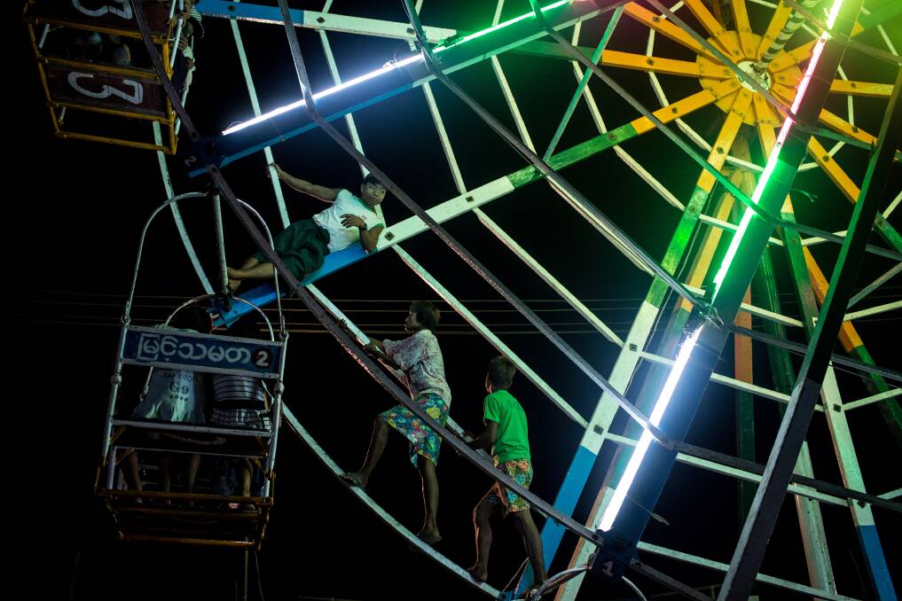 Ferris wheel attendants walk up the inside of the wheel to make it spin at a rural carnival in South Dagon Township on February 14, 2013 in Yangon, Burma. Photo: Chris McGrath/Getty Images
