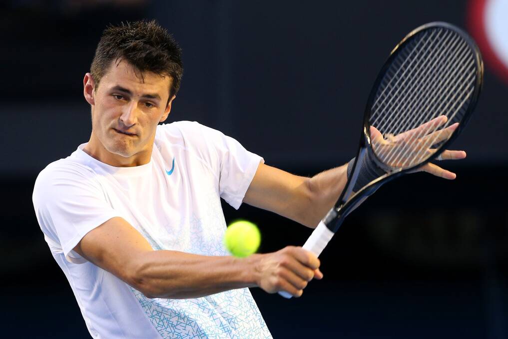 Bernard Tomic of Australia plays a backhand in his first round match against Leonardo Mayer of Argentina during day two of the 2013 Australian Open. Photo by Cameron Spencer/Getty Images