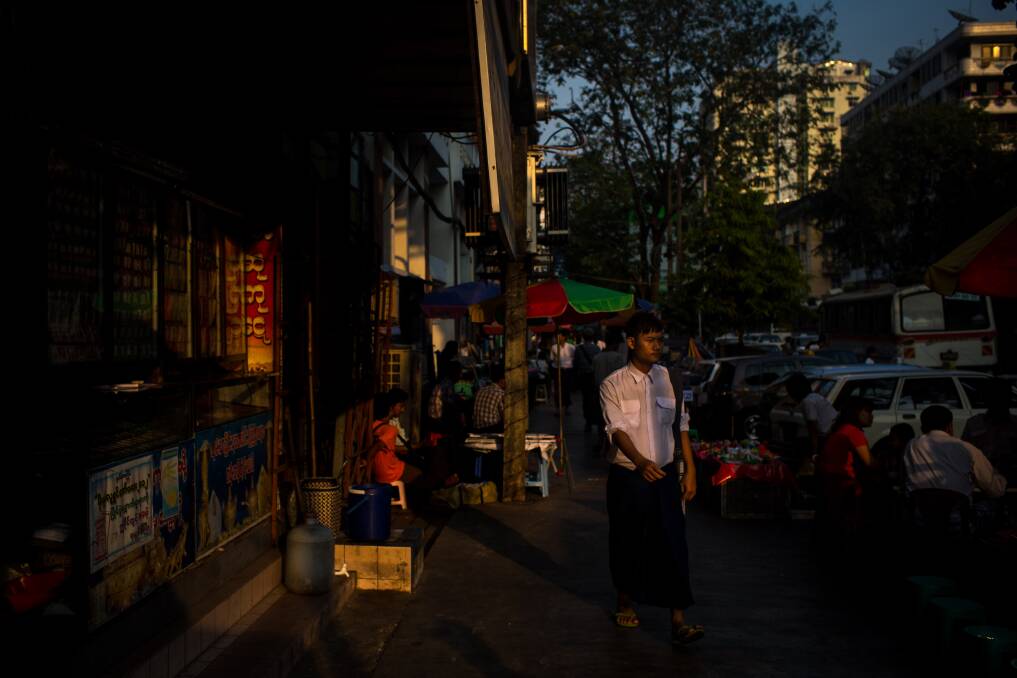 A man passes shops in downtown Yangon on February 13, 2013 in Yangon, Burma. Photo: Chris McGrath/Getty Images