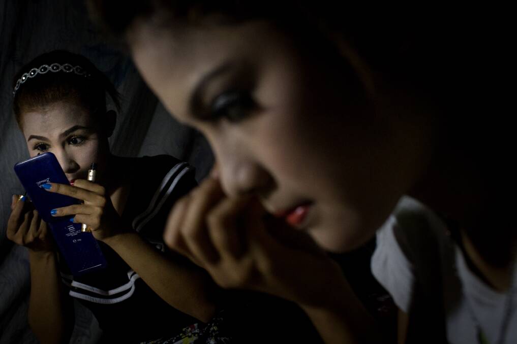 Performers Aye Thi Da and Thae Ei Tone of the Phoe Chit Naing Orchestra Band apply makeup before their performance at a rural carnival in South Dagon Township on February 14, 2013 in Yangon, Burma. Phoyo: Chris McGrath/Getty Images