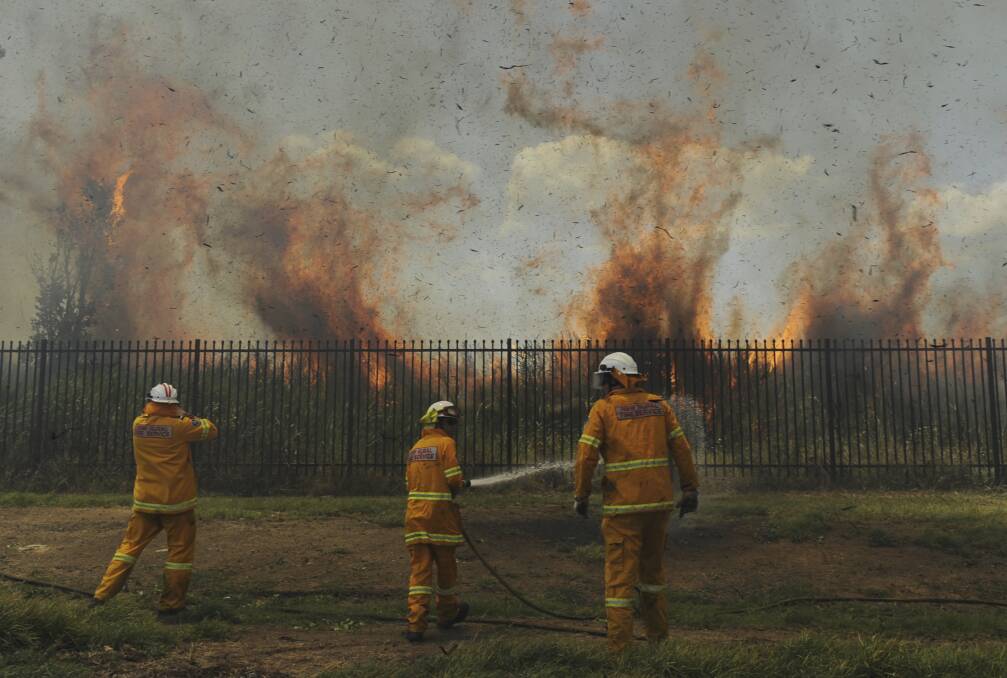 Rural Fire Service volunteers fight a grass fire on Andrews St, Penrith, west of Sydney. Photo: Mick Tsikas