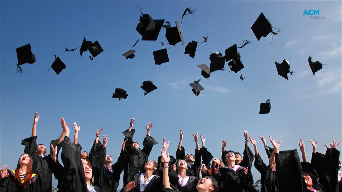 Graduating university students throw mortar board hats into the air. File picture. 