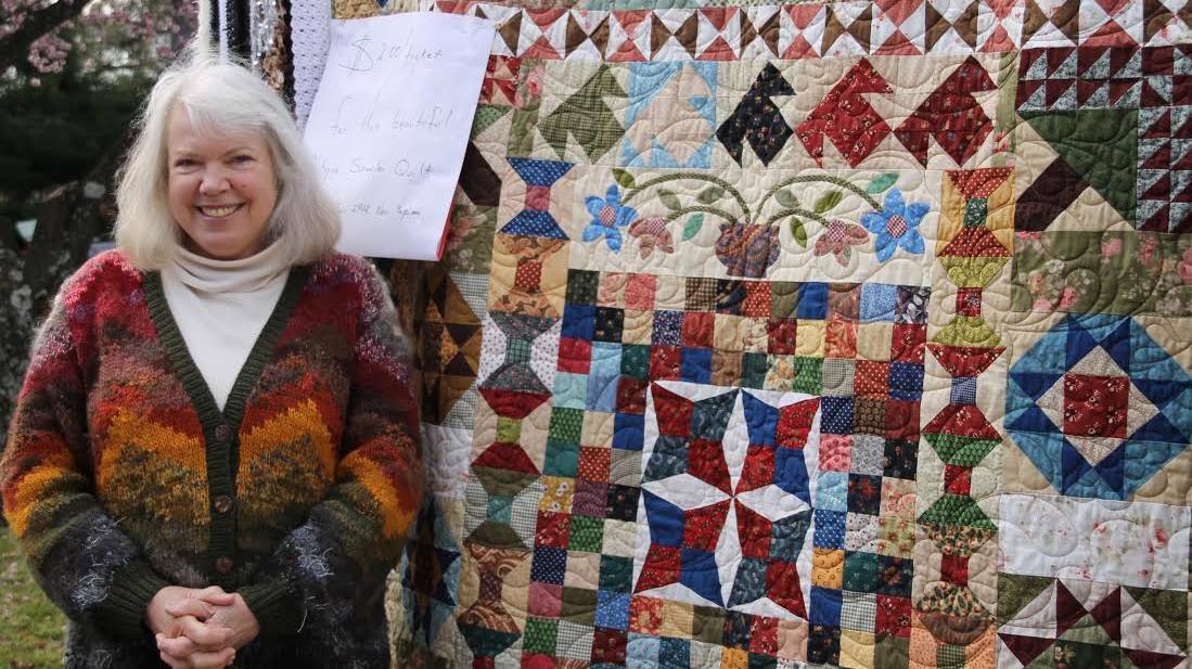 Cecily Bisset with her beautiful vintage-sampler quilt.