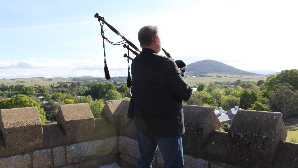 Stirring rendition: Bagpiper Chris Nelson plays against the backdrop of Braidwood and Mt Gillamatong. Photo: Robin Tennant-Wood