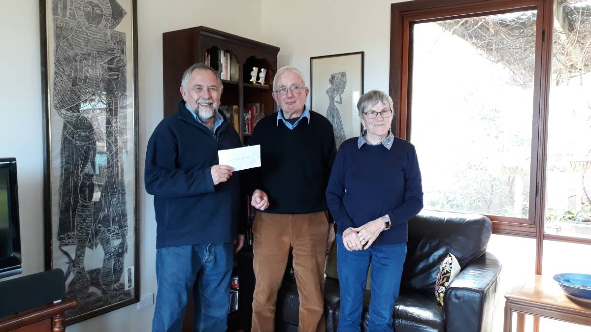 Doug Hynd (left), chair of  Canberra Refugee Support, receiving a cheque from Michael Merrony and Pauline Coady