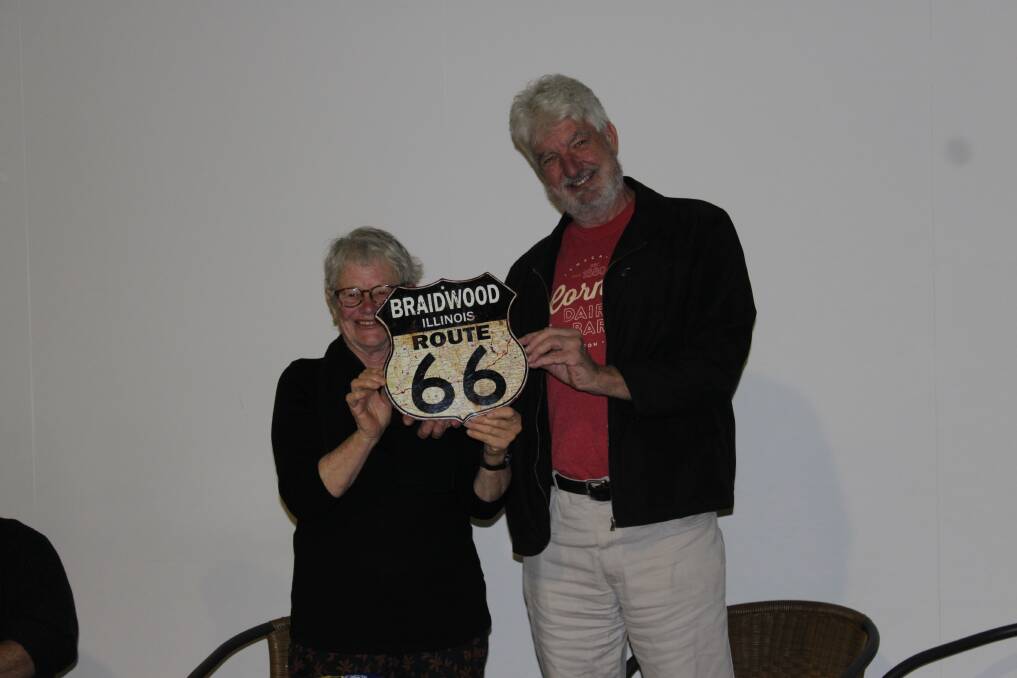 Paul Cockram presents the President of Braidwood and the Villages Tourism, Sandra Hand, with the Braidwood Illinois "Route 66" sign
