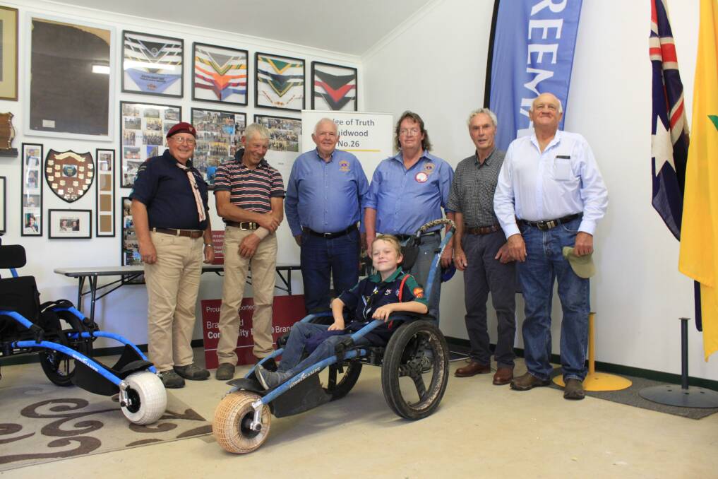 Wayne Cramp (left) with representatives of the Braidwood Lodge of Truth and Lions, with Jacob in the wheelchair he used during the Australian Jamboree in Adelaide