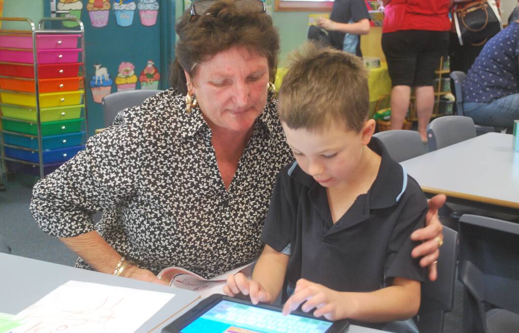 Jenny Smith watches grandson Lachlan run through some apps on his iPad. 