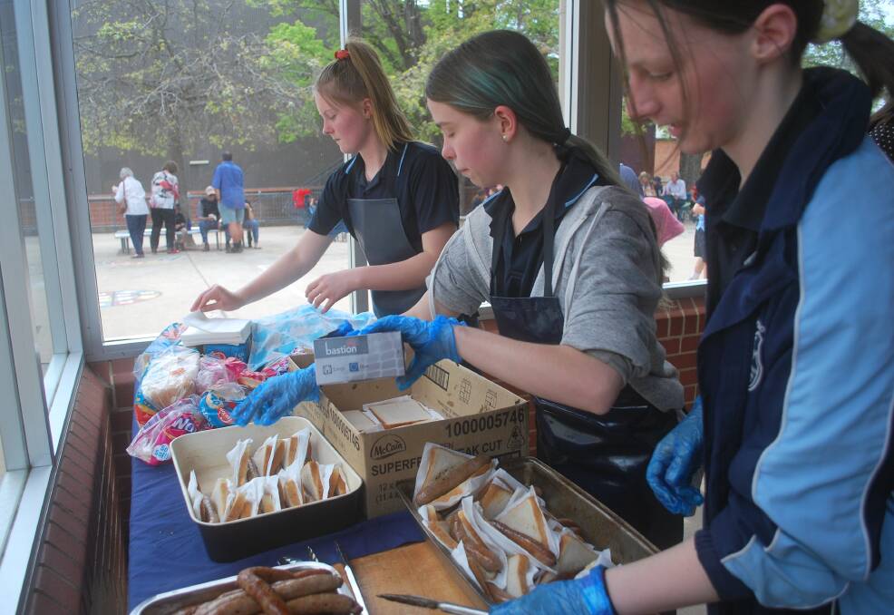 Year 11 Work Studies students, L-R Ella Duff, Karla Shaw and Tanisha Williams work frantically to keep the food coming at the barbecue.