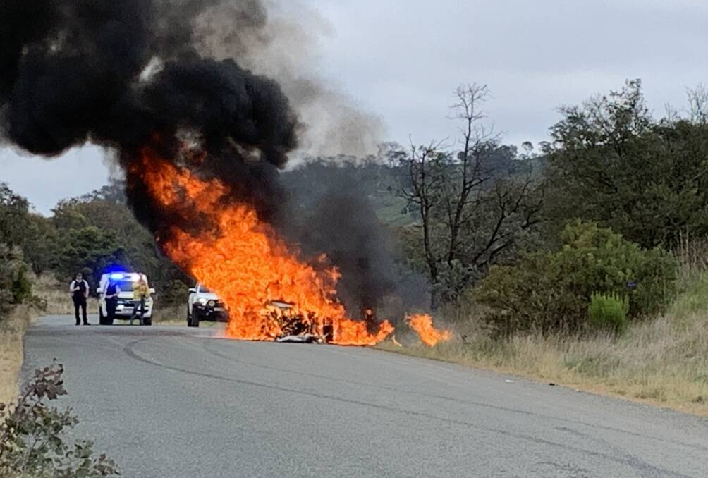 Police watch on as a stolen car burns near Eaglehawk. Picture by Peter Brewer