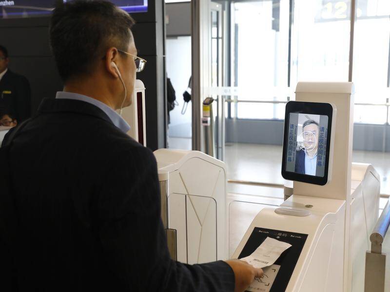 A man at a self-service boarding machine with facial recognition capabilities at Shanghai airport.