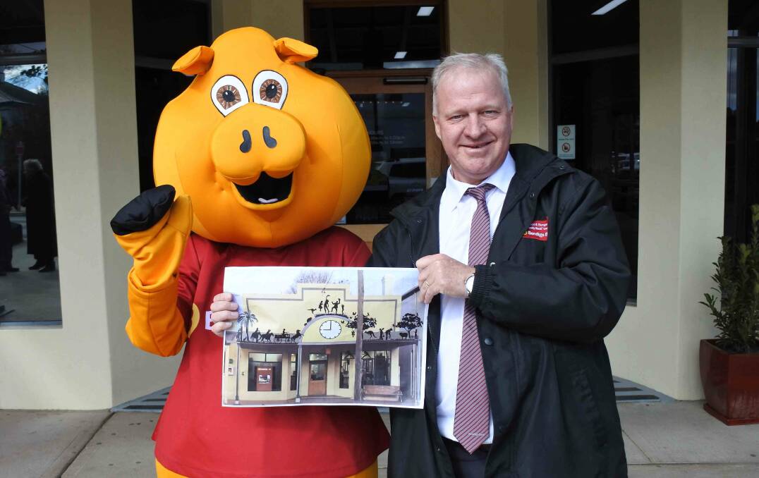 TIME'S UP: Branch Manager Nick Fry and 'Piggy' show off plans for the clock at the bank's birthday in September. Photo: Elspeth Kernebone.