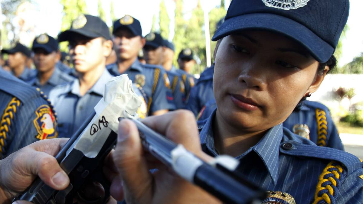 Philippine National Police tape the muzzles of their guns to avoid accidental discharges during New Year's celebrations. Photo: REUTERS