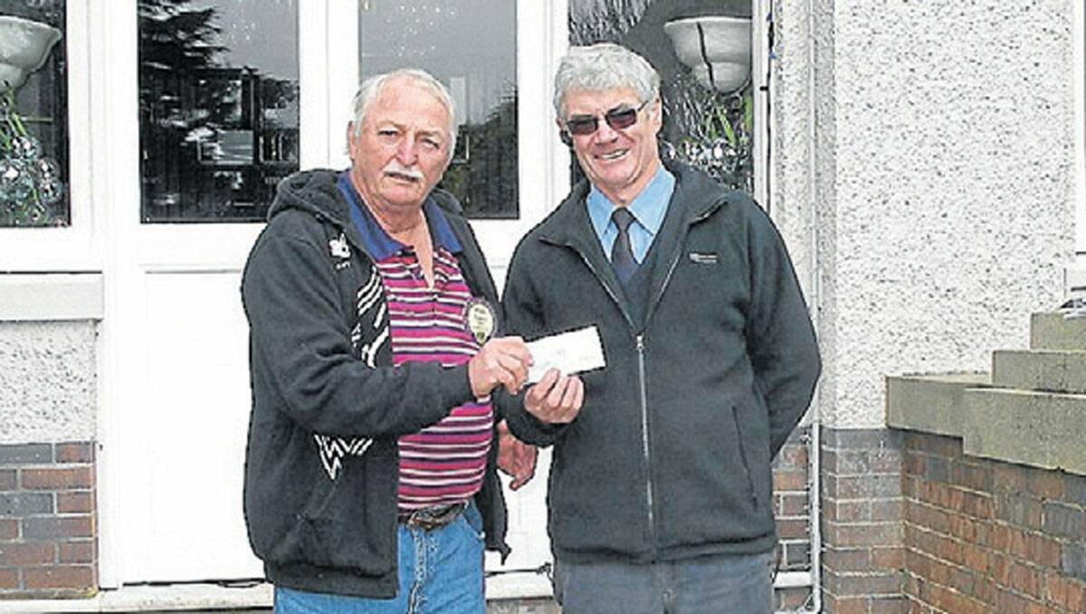Phil Lewis Treasurer of the Braidwood Lions presenting the cheque to Ian Bensley outside of the historic old Robertson Hotel. 