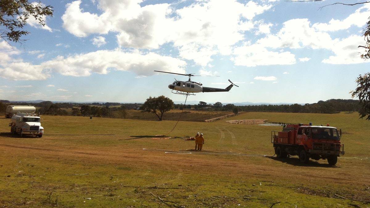 Mongarlowe’s RFS crew hot refuelling a water bombing helicopter at Wog Wog on Monday. 