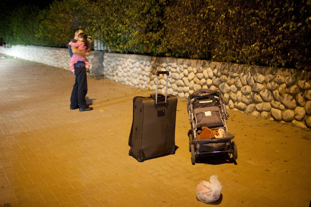 An Israeli man and child wait for a bus to leave town on November 14, 2012 in Netivot, Israel. Photo by Uriel Sinai/Getty Images