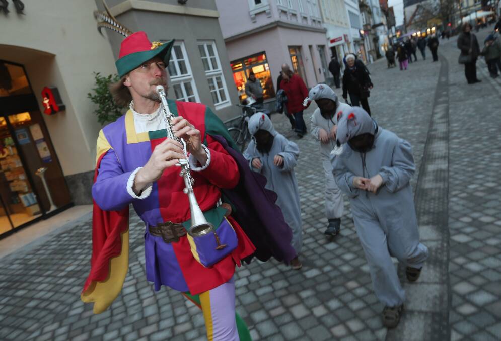 The Pied Piper of Hamelin, actually city tourism employee Michael Boyer, leads local children dressed as rats through a quiet street in Hameln, Germany. Photo by Sean Gallup/Getty Images