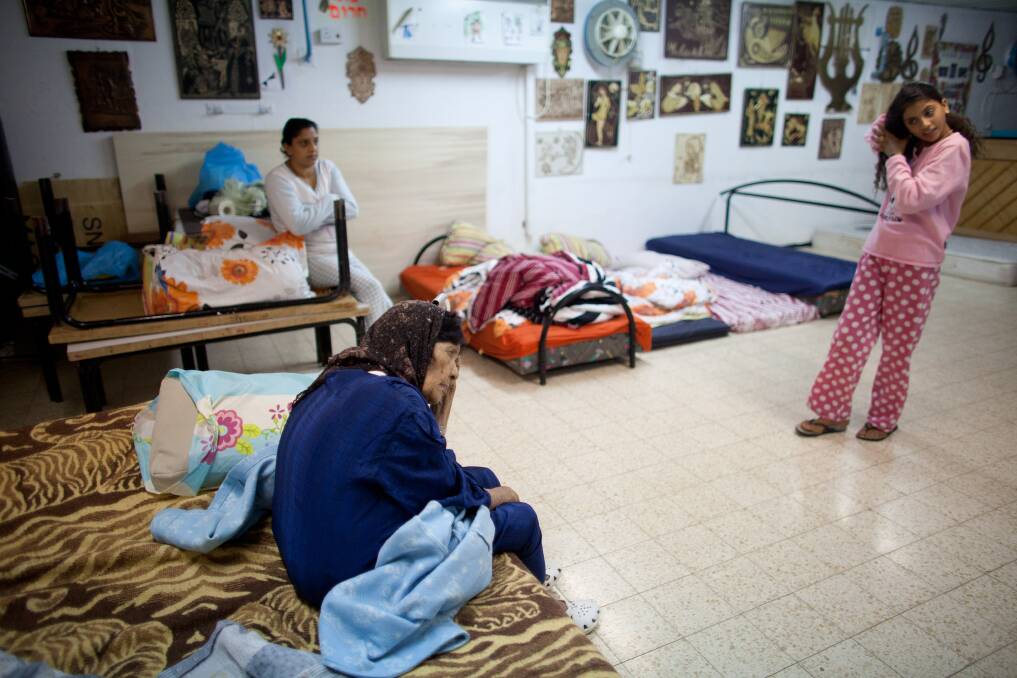 An Israeli woman and children sit inside a bomb shelter in Netivot, Israel. Photo by Uriel Sinai/Getty Images