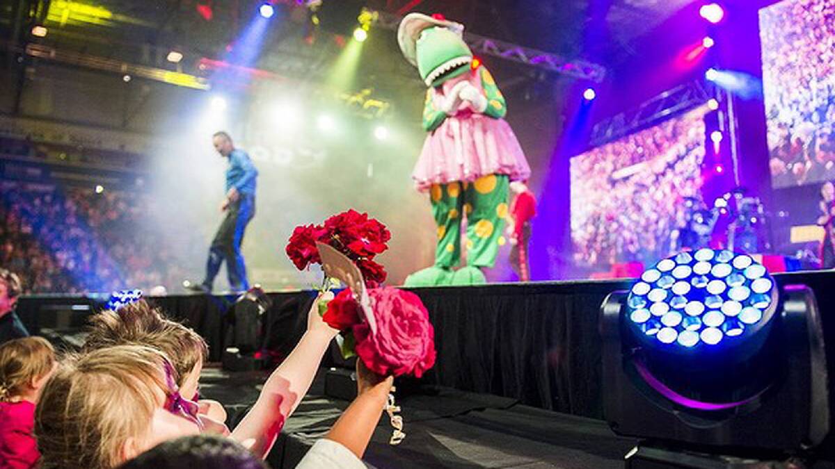 The Wiggles perform at AIS Arena. Kids hold up flowers for Dorothy the Dinosaur. Photo: Rohan Thomson