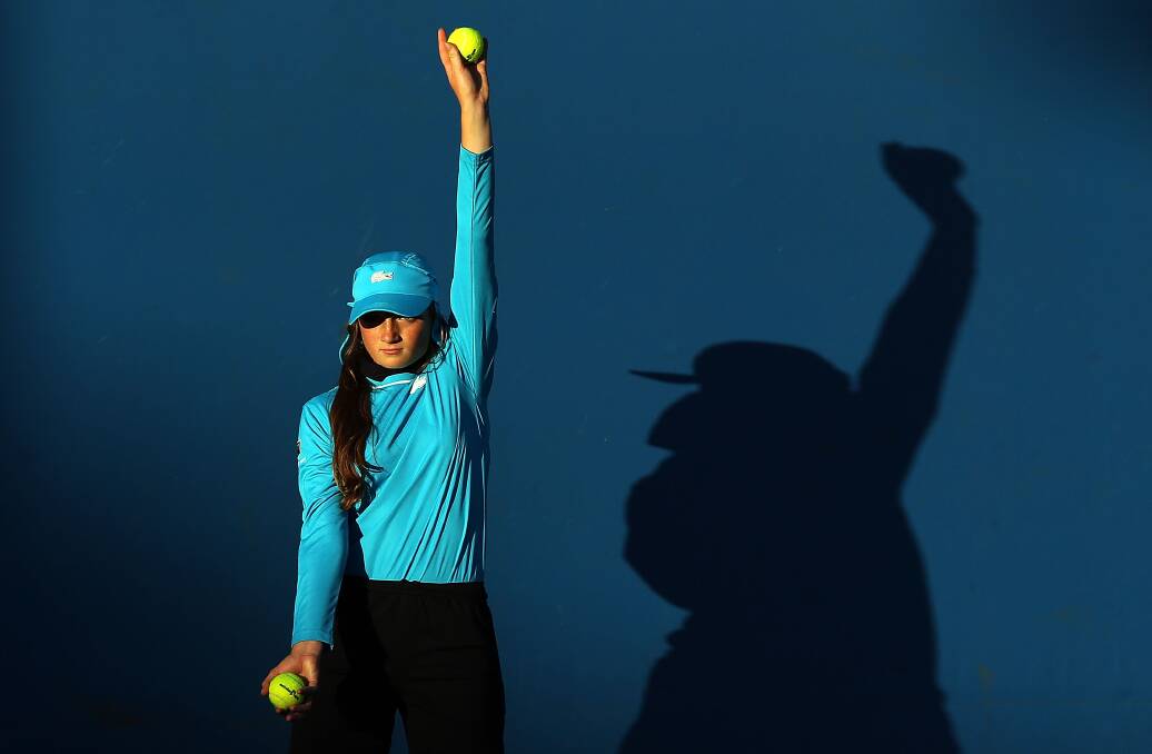 A ballgirl holds a ball up. Photo by Michael Dodge/Getty Images