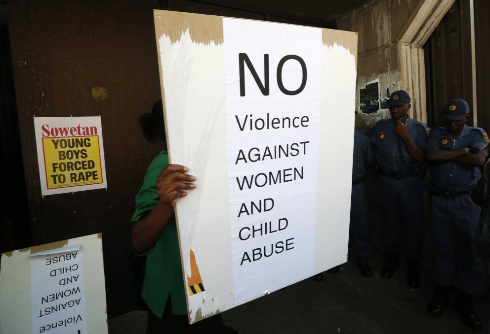 A woman holds up a sign as she and others protest outside the Pretoria Magistrates court during the bail application of "Blade Runner" Oscar Pistorius February 19, 2013. Photo: REUTERS/Mike Hutchings